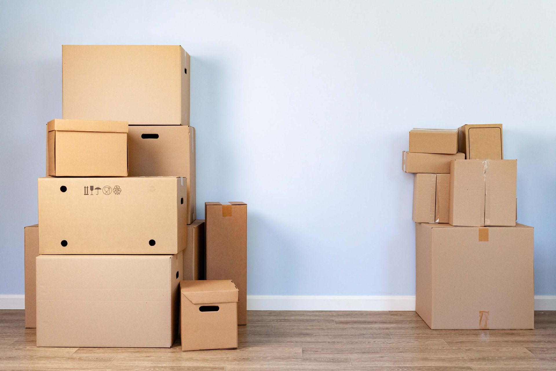 Un montón de cajas de cartón están apiladas una encima de otra en una habitación.