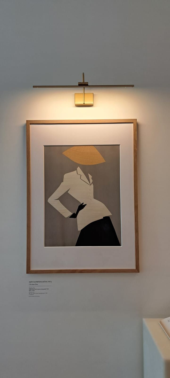 Une illustration minimaliste encadrée représentant une silhouette portant un chapeau et un blazer