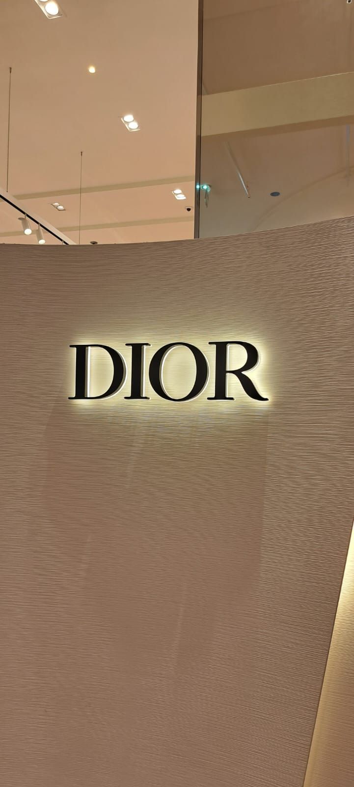 Un logo DIOR rétroéclairé et lumineux, apposé sur un mur