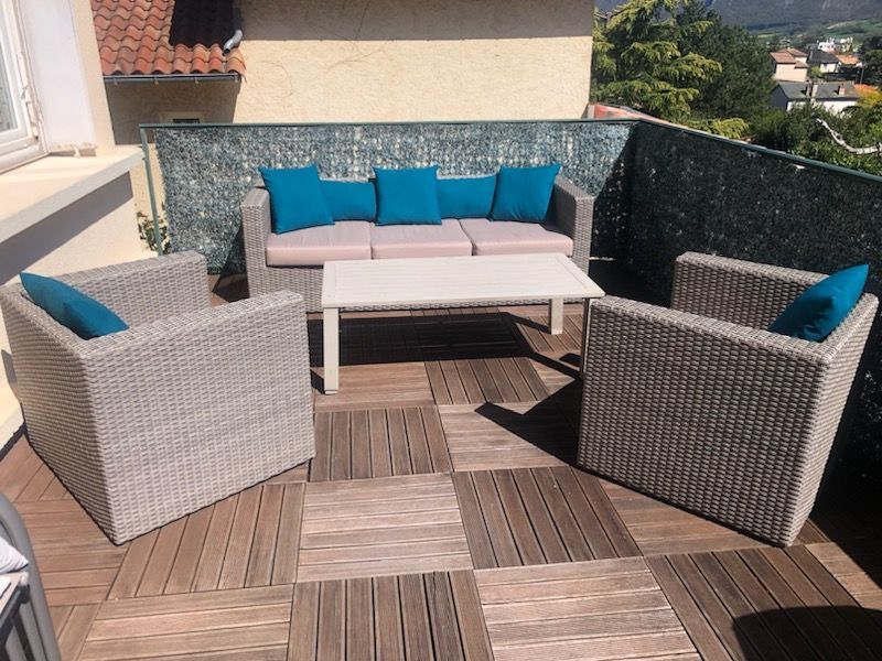 Terrasse de jardin avec un canapé et deux fauteils 