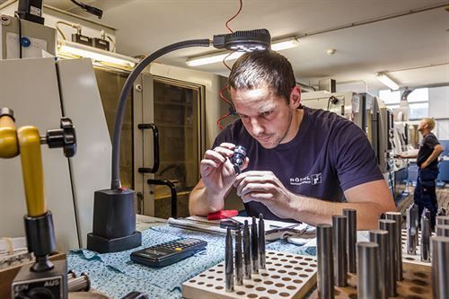 Ein Mann arbeitet in einer Fabrik an einem Stück Metall.