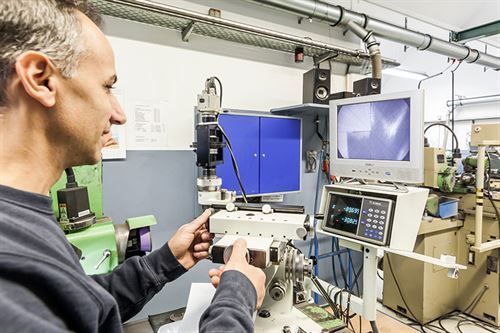Ein Mann arbeitet in einer Fabrik an einer Maschine.