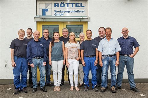 Eine Gruppe von Menschen steht vor einem Gebäude mit der Aufschrift „Rottel“