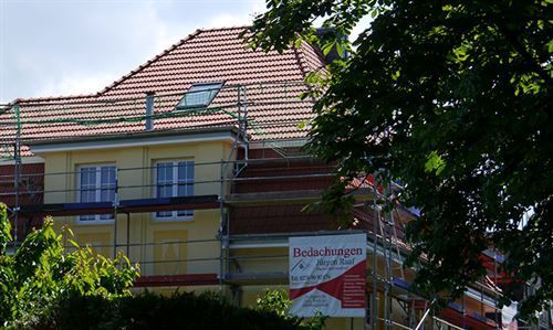 Ein Gebäude mit Gerüsten darum herum und einem Schild mit der Aufschrift
