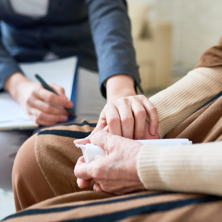 Persona tomando de la mano a otra persona durante una sesión de asesoramiento.