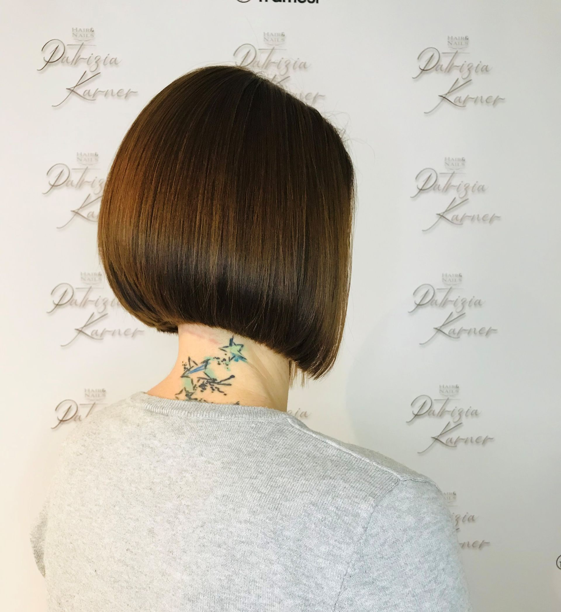 Hände halten Schere und Kamm und schneiden Haare vor dunklem Hintergrund.