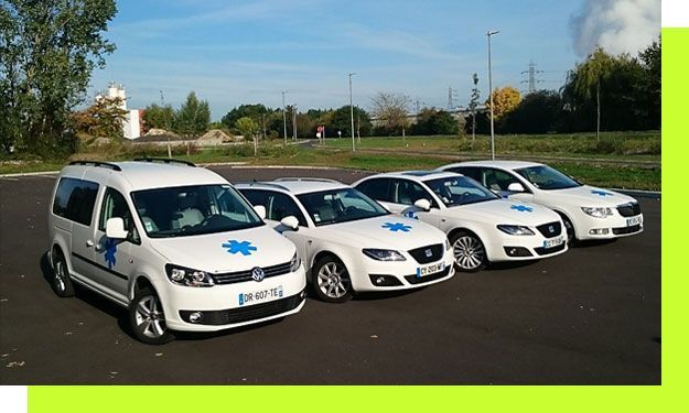 Des ambulances blanches garées en rang, chacune arborant un emblème de croix bleue.