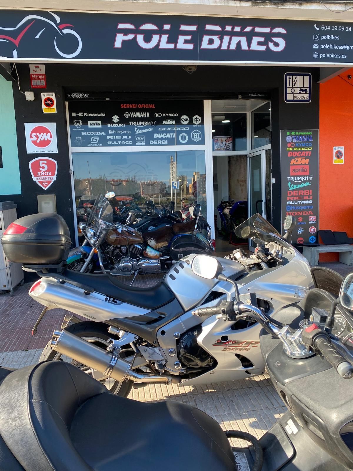 Una motocicleta está estacionada frente a una tienda de bicicletas Pole.