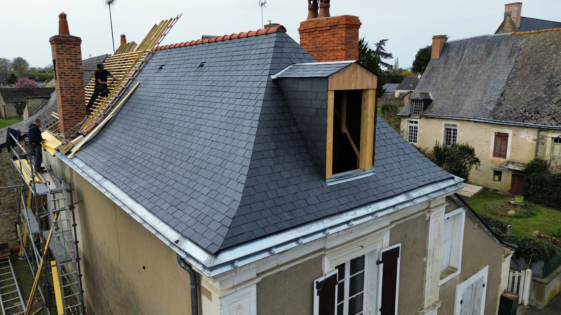 De la zinguerie sur un toit noir.