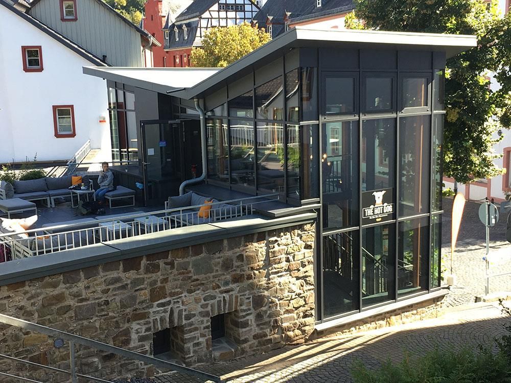 Ein Gebäude mit vielen Fenstern steht neben einer Steinmauer