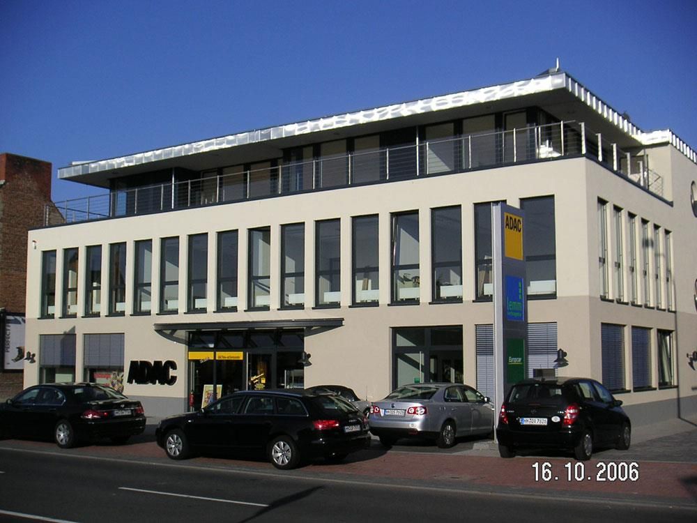 Autos parken vor einem Gebäude mit der Aufschrift RMC
