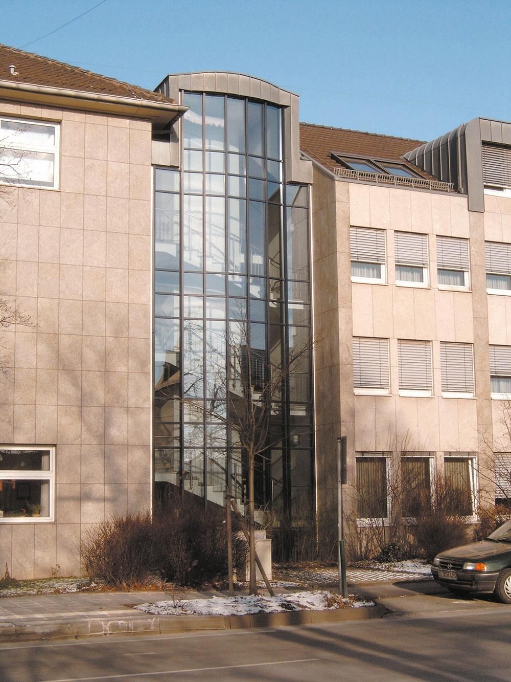Ein Gebäude mit vielen Fenstern und einem davor geparkten Auto