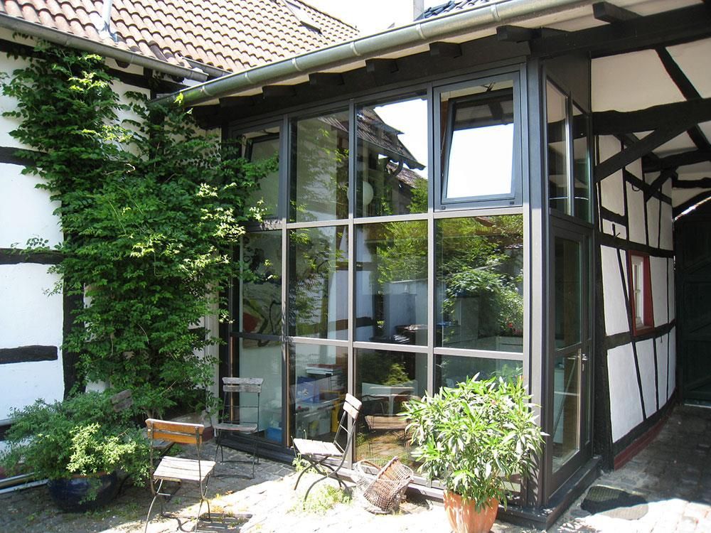 Ein Haus mit vielen Fenstern und Pflanzen