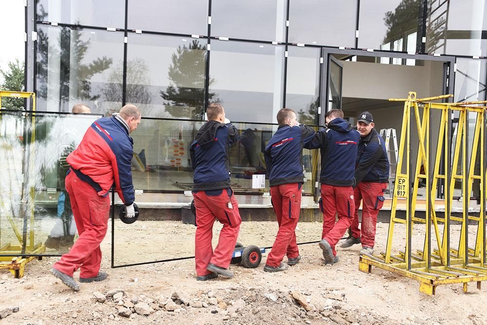 Eine Gruppe von Männern trägt ein großes Stück Glas