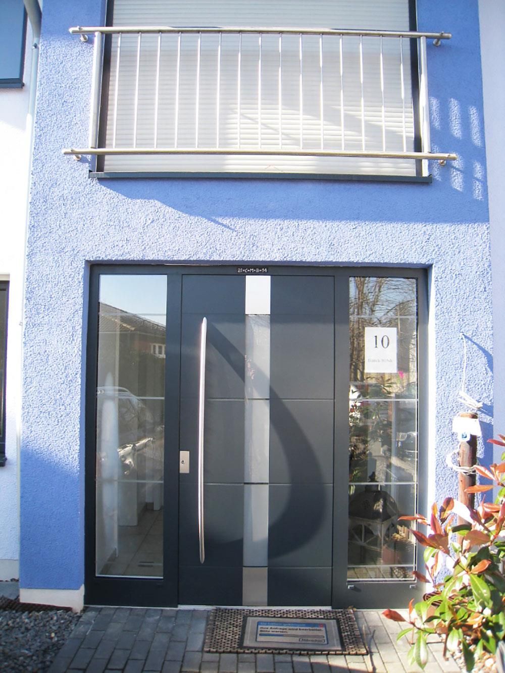 Ein blau-weißes Gebäude mit einer schwarzen Tür