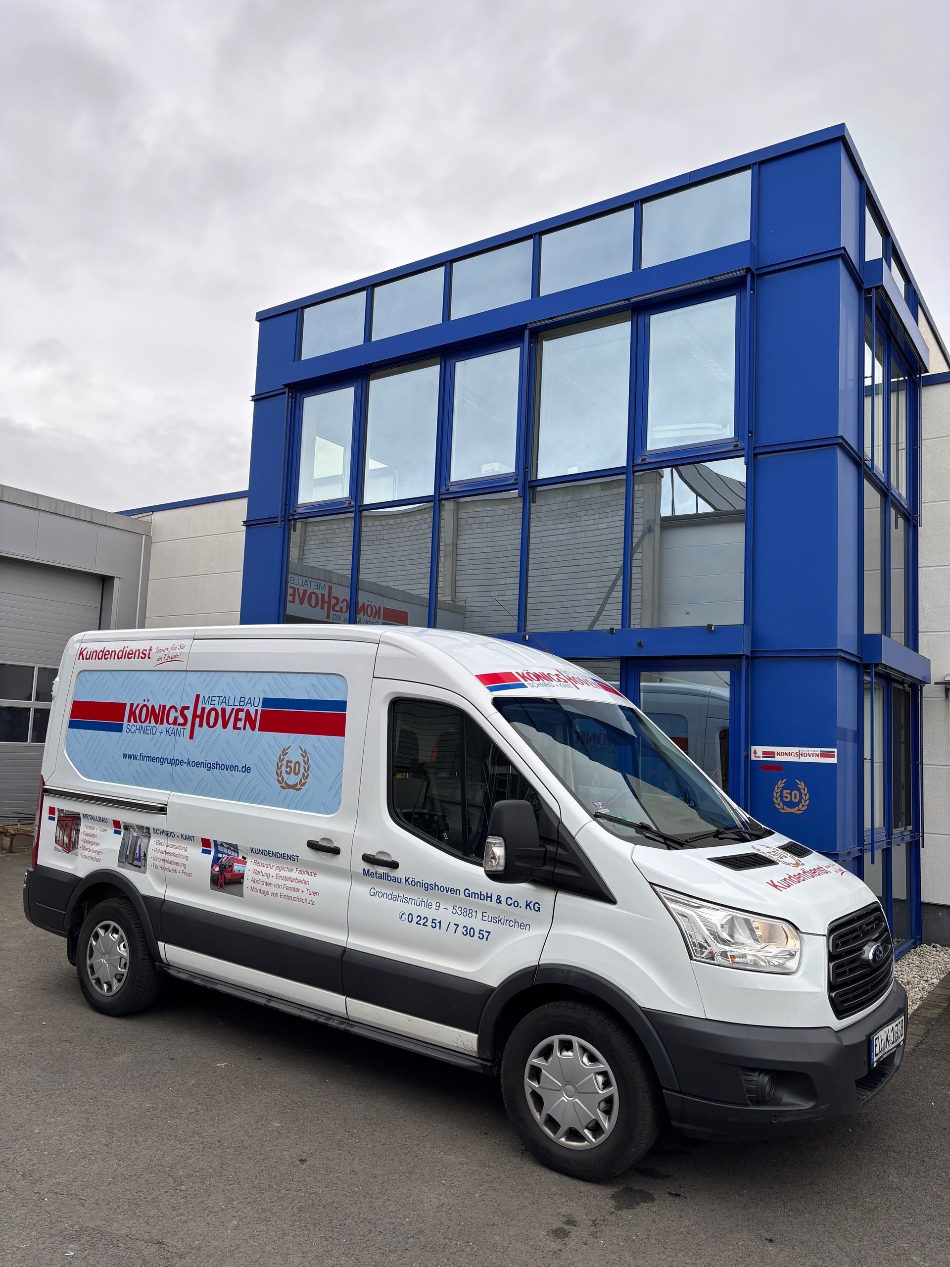 Ein Mann steht vor einem weißen Lieferwagen mit der Aufschrift „Kundedienst“