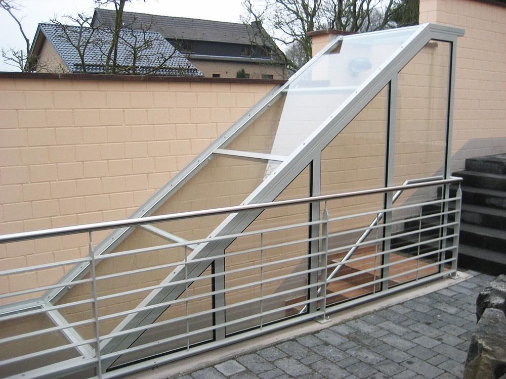 Eine Treppe mit einem Edelstahlgeländer, die zu einem Gebäude hinaufführt