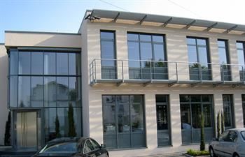 Ein Gebäude mit vielen Fenstern und davor geparkten Autos.