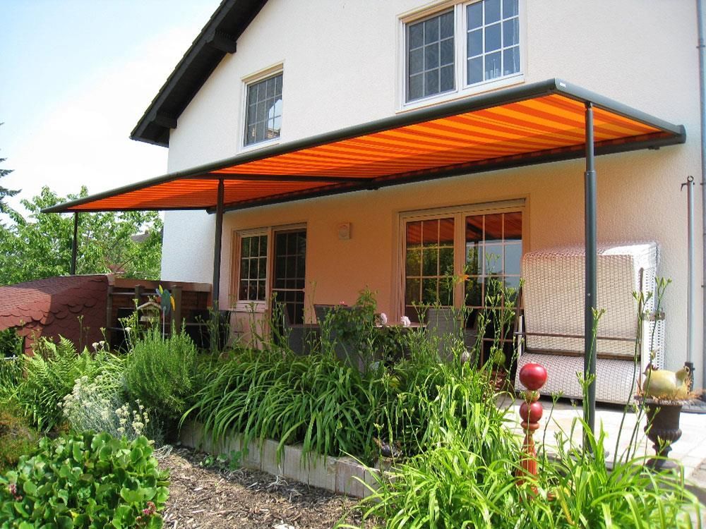 Ein Haus mit einer orangefarbenen Markise über der Veranda