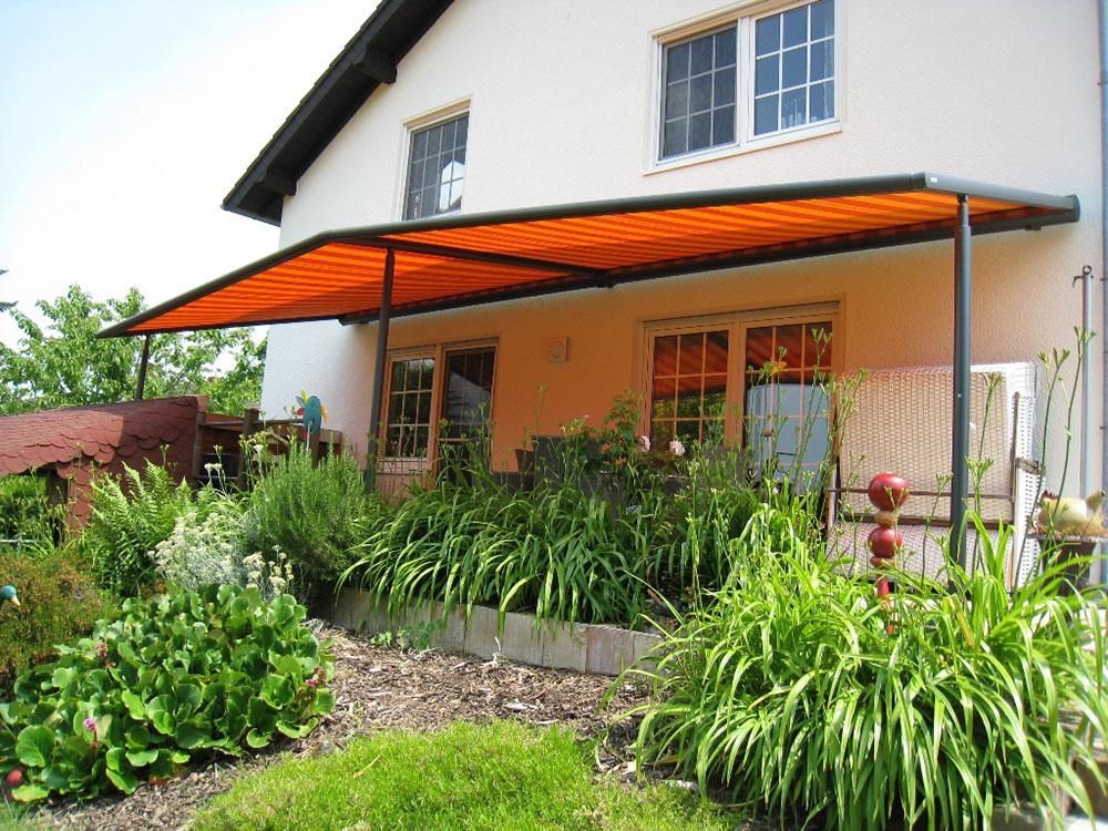 Ein Haus mit einer orangefarbenen Markise über der Veranda