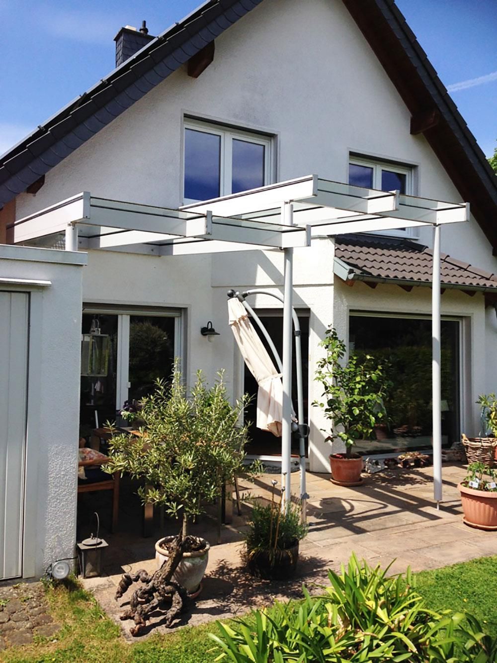 Ein weißes Haus mit einer Pergola davor
