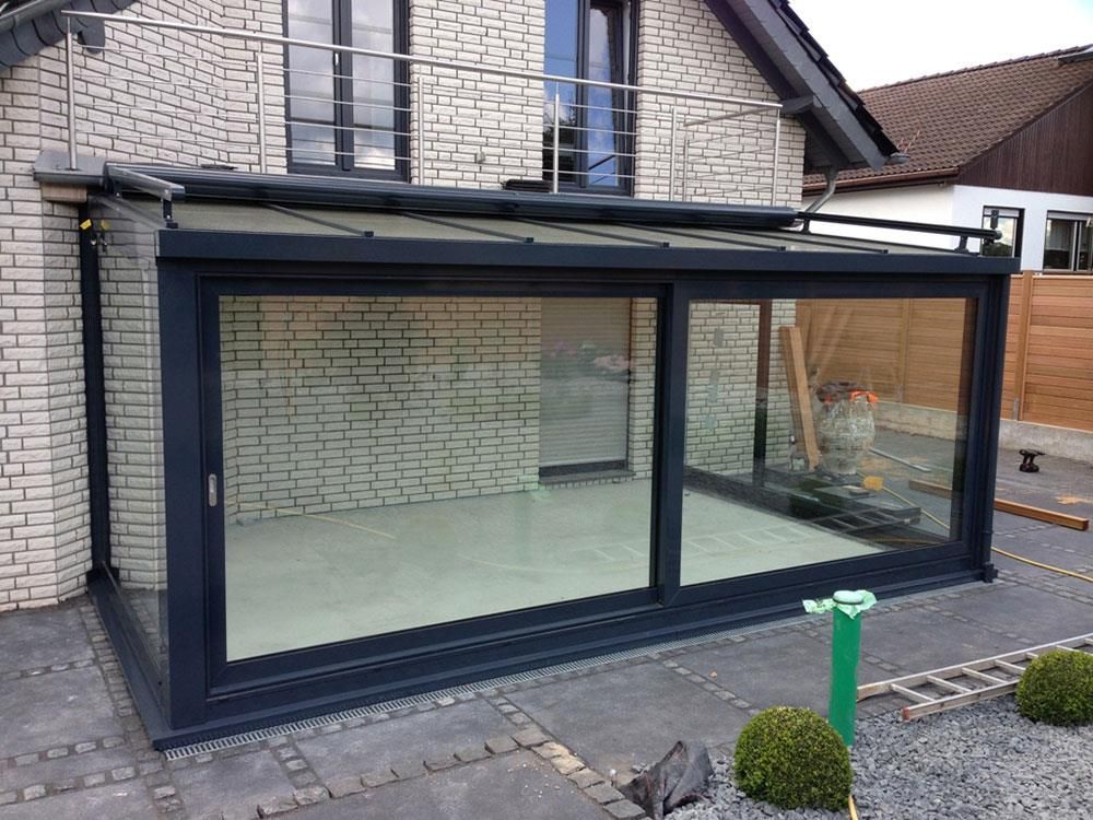 Ein weißes Backsteinhaus mit einem großen Glasraum davor