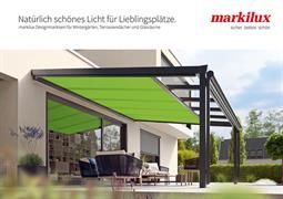 Eine grüne Markise steht auf einer Terrasse neben einem Haus.