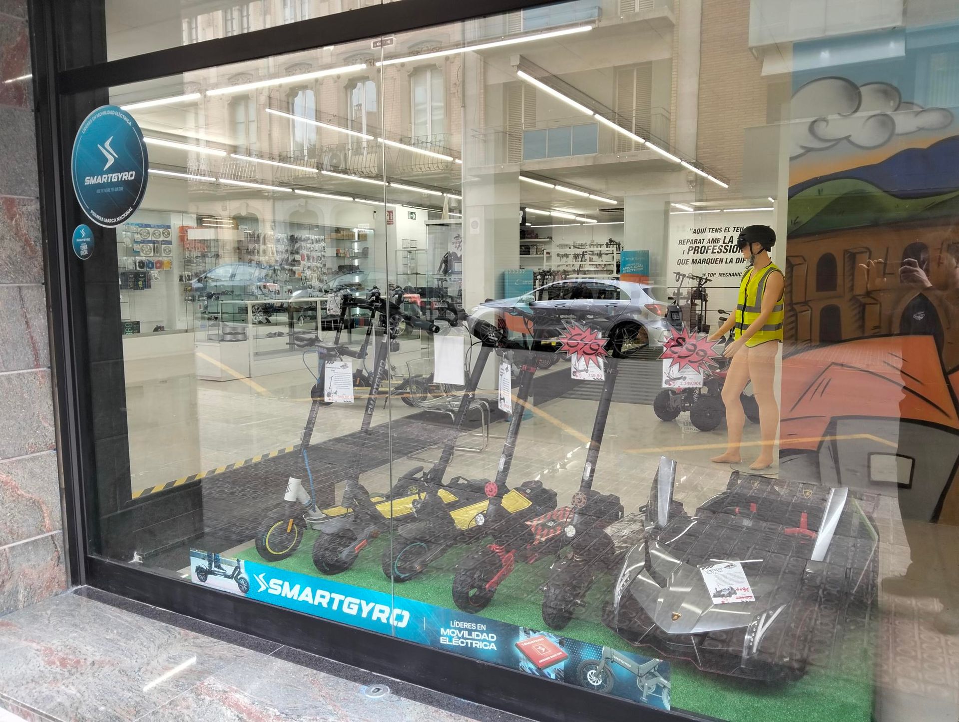 Una fila de patinetes eléctricos están alineados en una tienda.