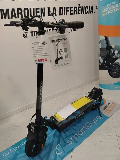 Un patinete eléctrico está en exhibición en una tienda con un cartel que dice marquen la diferencia