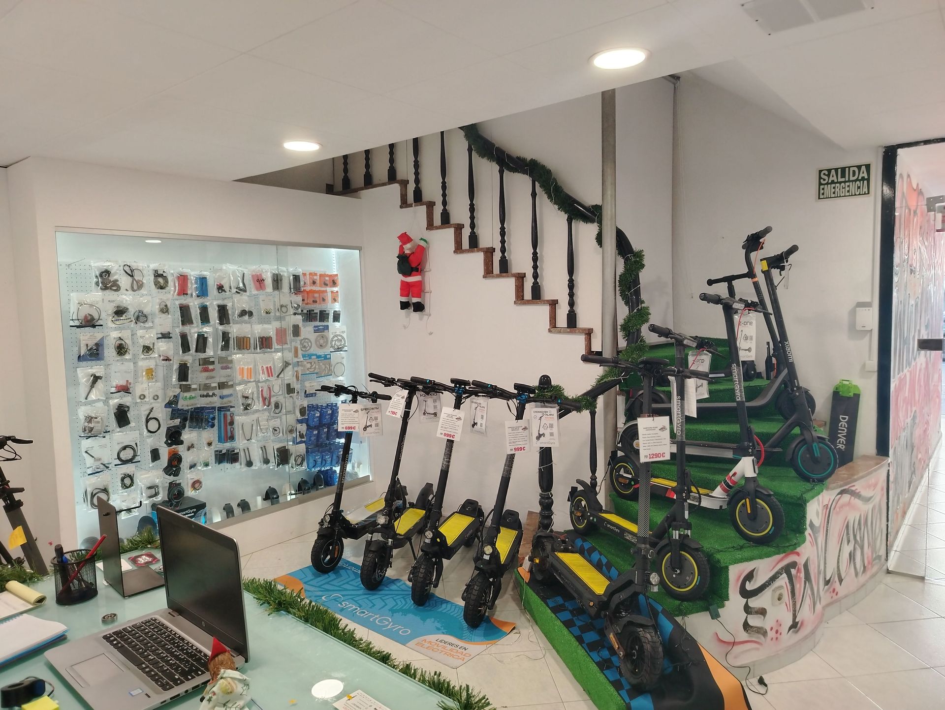 Una fila de patinetes eléctricos están alineados en una tienda.