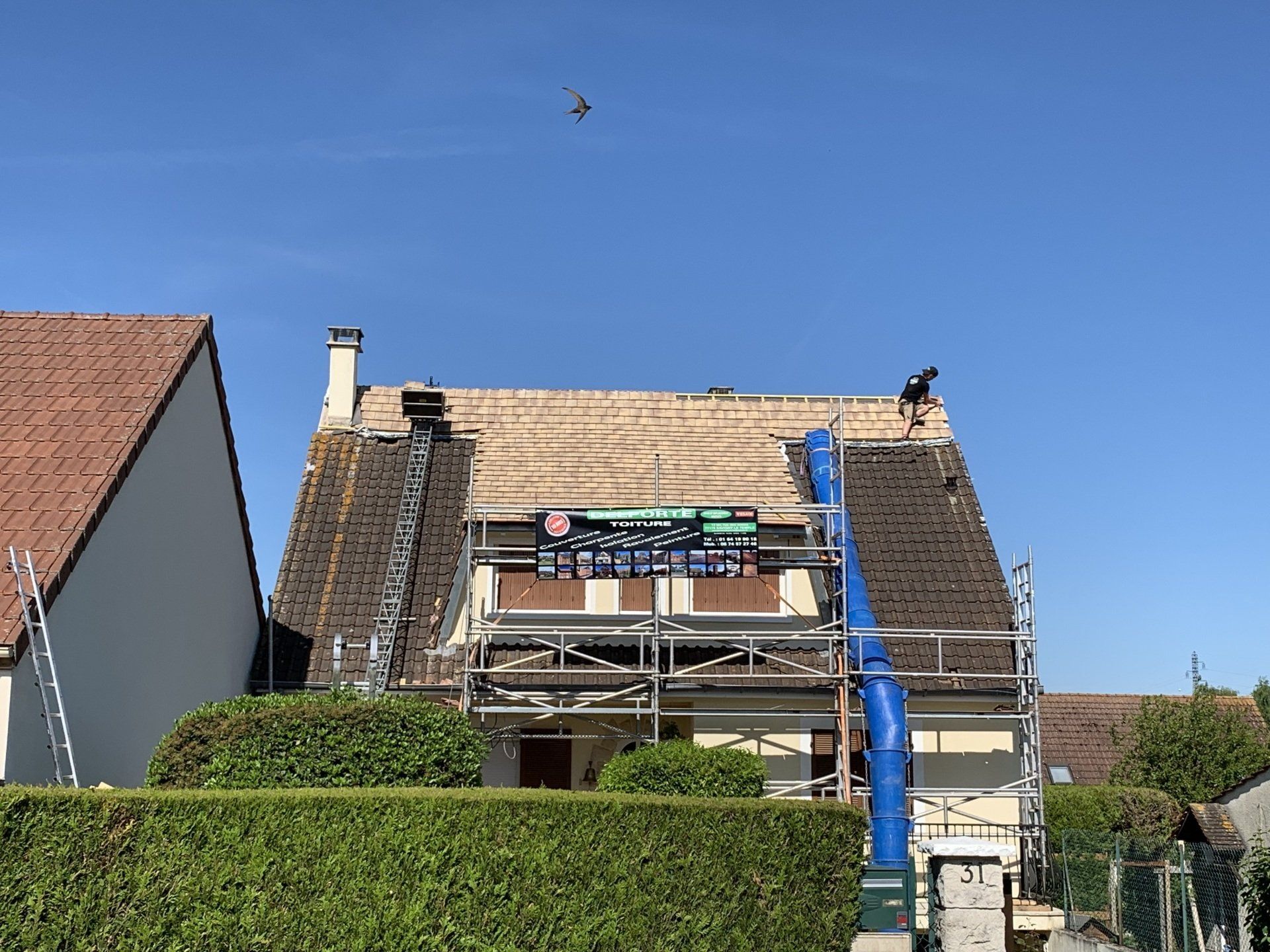 Maison avec échafaudage pour réalisation de travaux de toiture