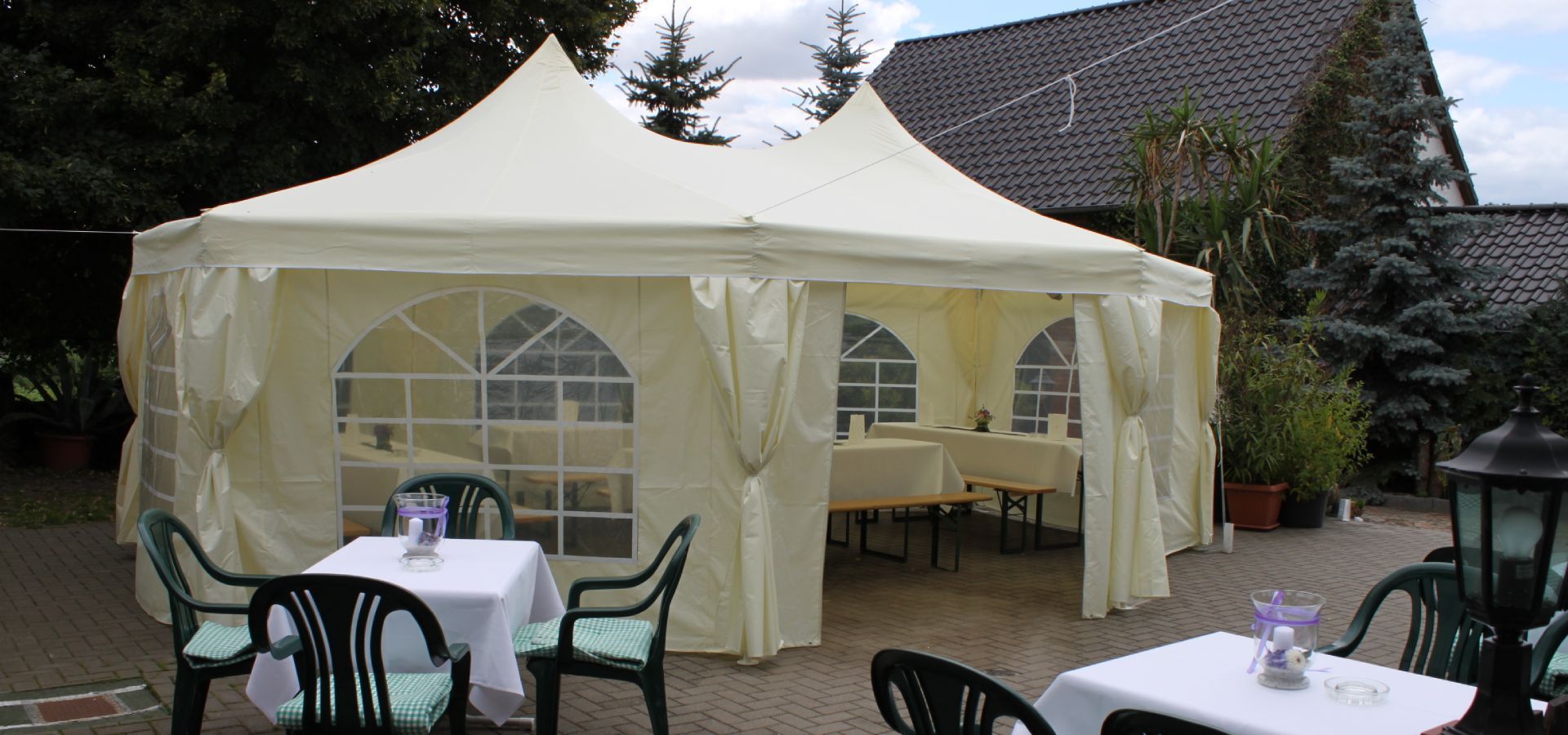 Außenbereich mit Tischen und Zeltpavillon