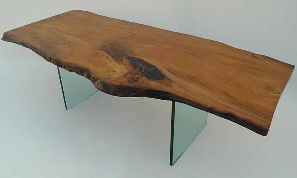 ein Holztisch mit Glasbeinen auf weißem Hintergrund .