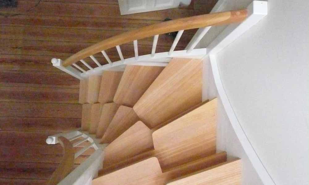 eine Holztreppe mit weißem Geländer und Holzstufen in einem Haus .