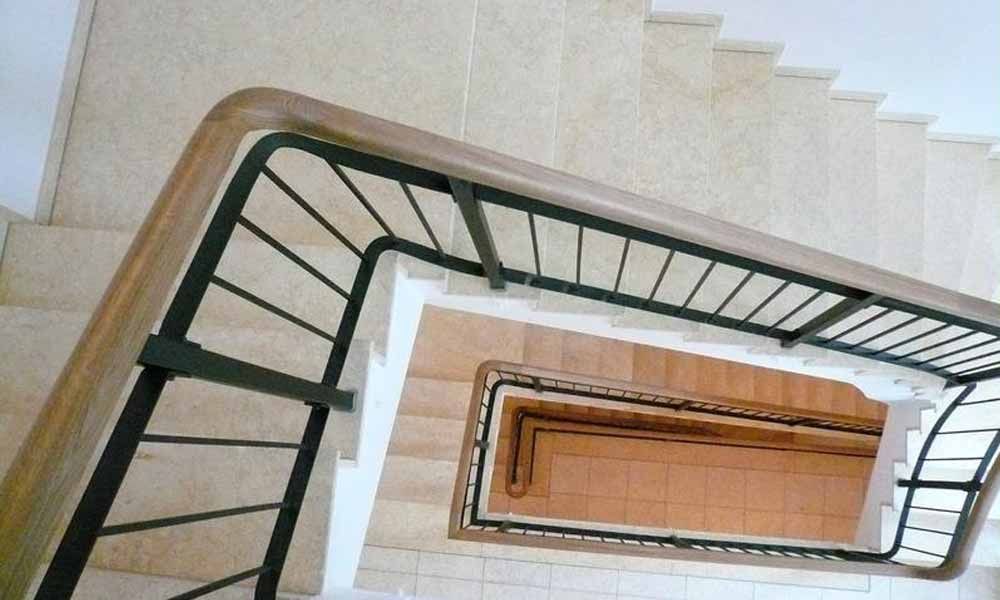 ein Blick von oben auf eine Treppe mit Holzhandlauf und Metallgeländer .