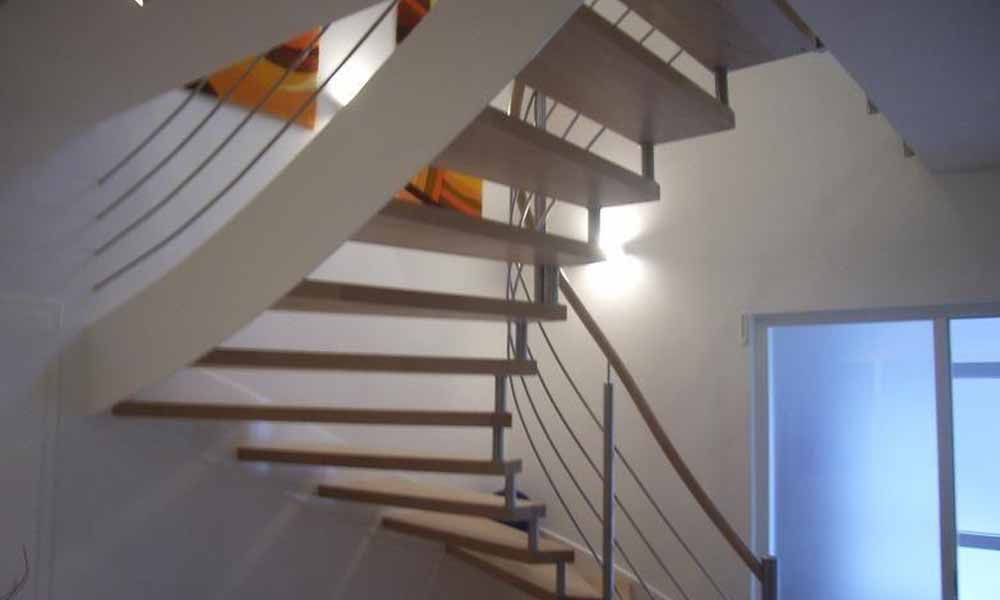 eine Holztreppe mit einem Metallgeländer in einem Haus .