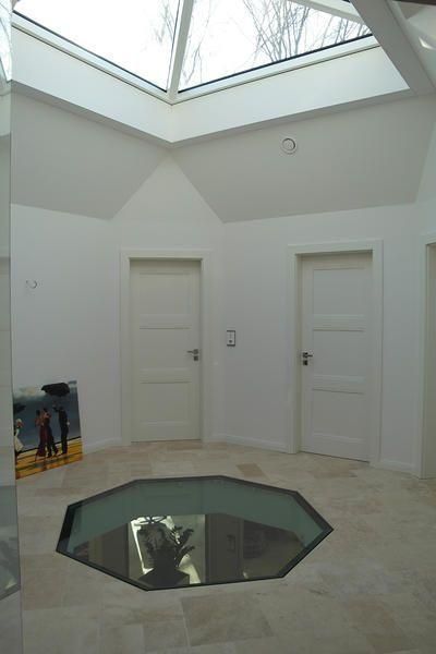 ein Flur mit weißen Türen und einem Dachfenster .