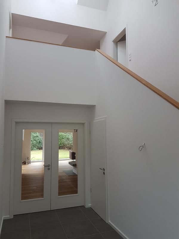 ein Flur mit weißen Wänden und einer Treppe