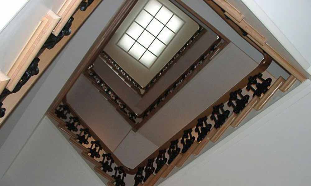 eine Treppe mit schwarzen Handläufen und einem Fenster