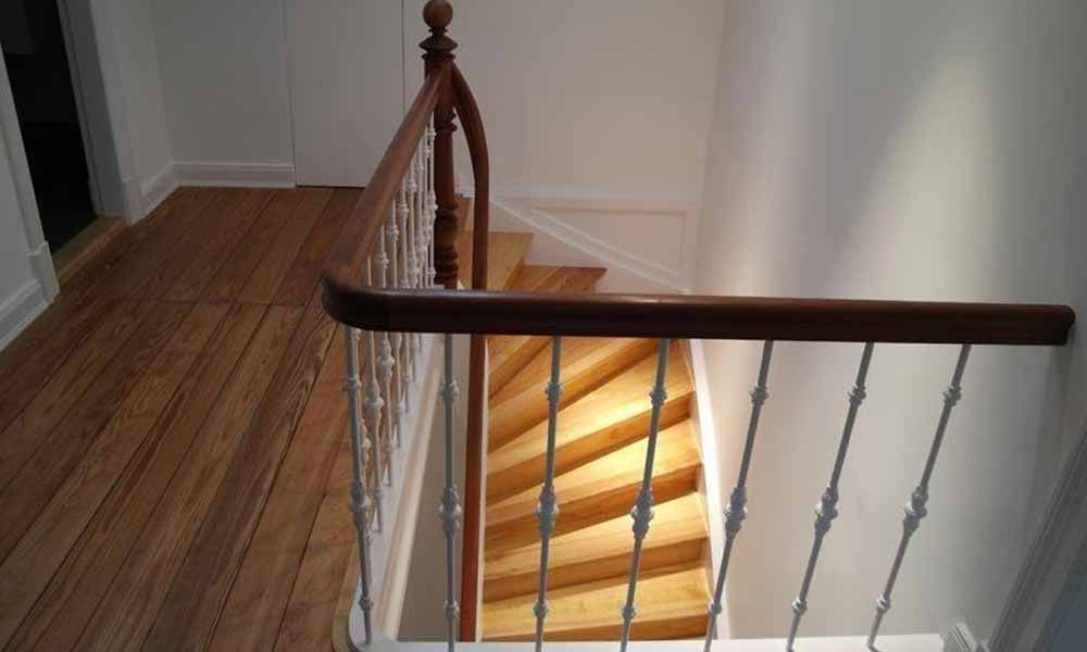 eine Holztreppe mit weißem Geländer in einem Haus .