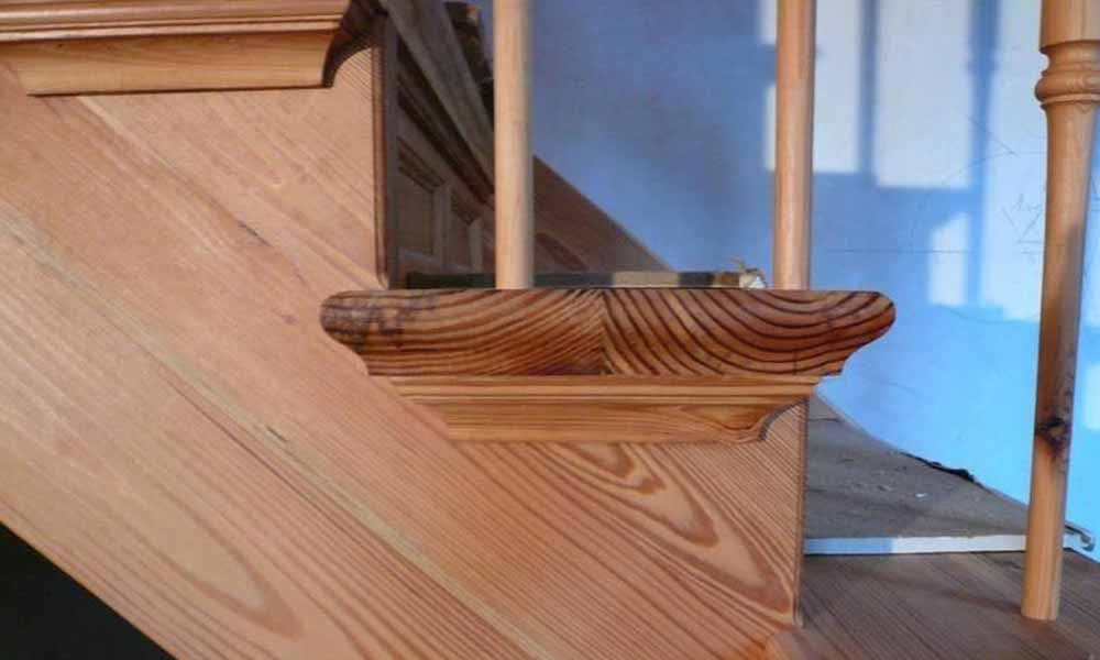 eine Nahaufnahme einer Holztreppe mit Handlauf und Handlauf