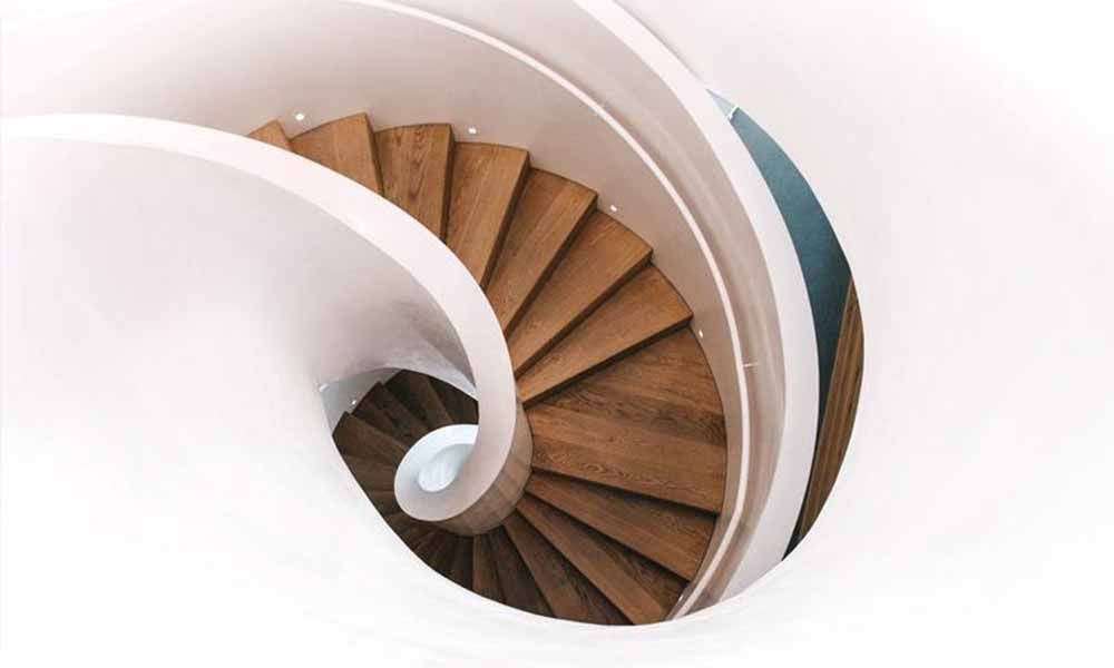 Die Treppe ist aus Holz und weiß und sieht aus wie eine Spirale .