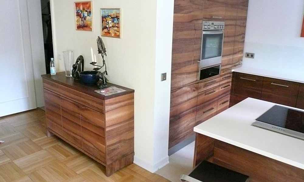 eine Küche mit Holzschränken und einem Herd