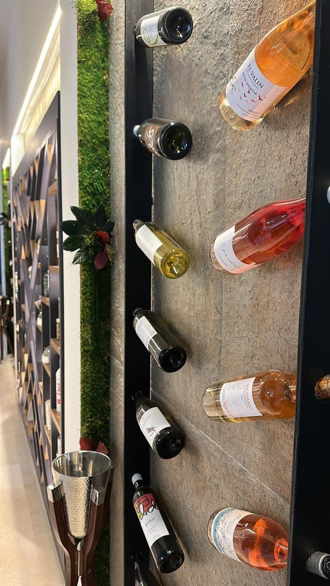 Una fila de botellas de vino colgadas en una pared.