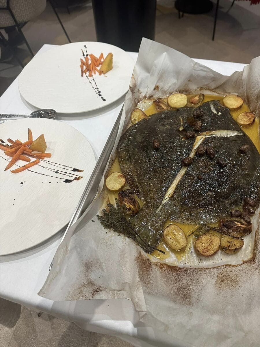 Hay dos platos de comida en una mesa al lado de un trozo grande de comida.