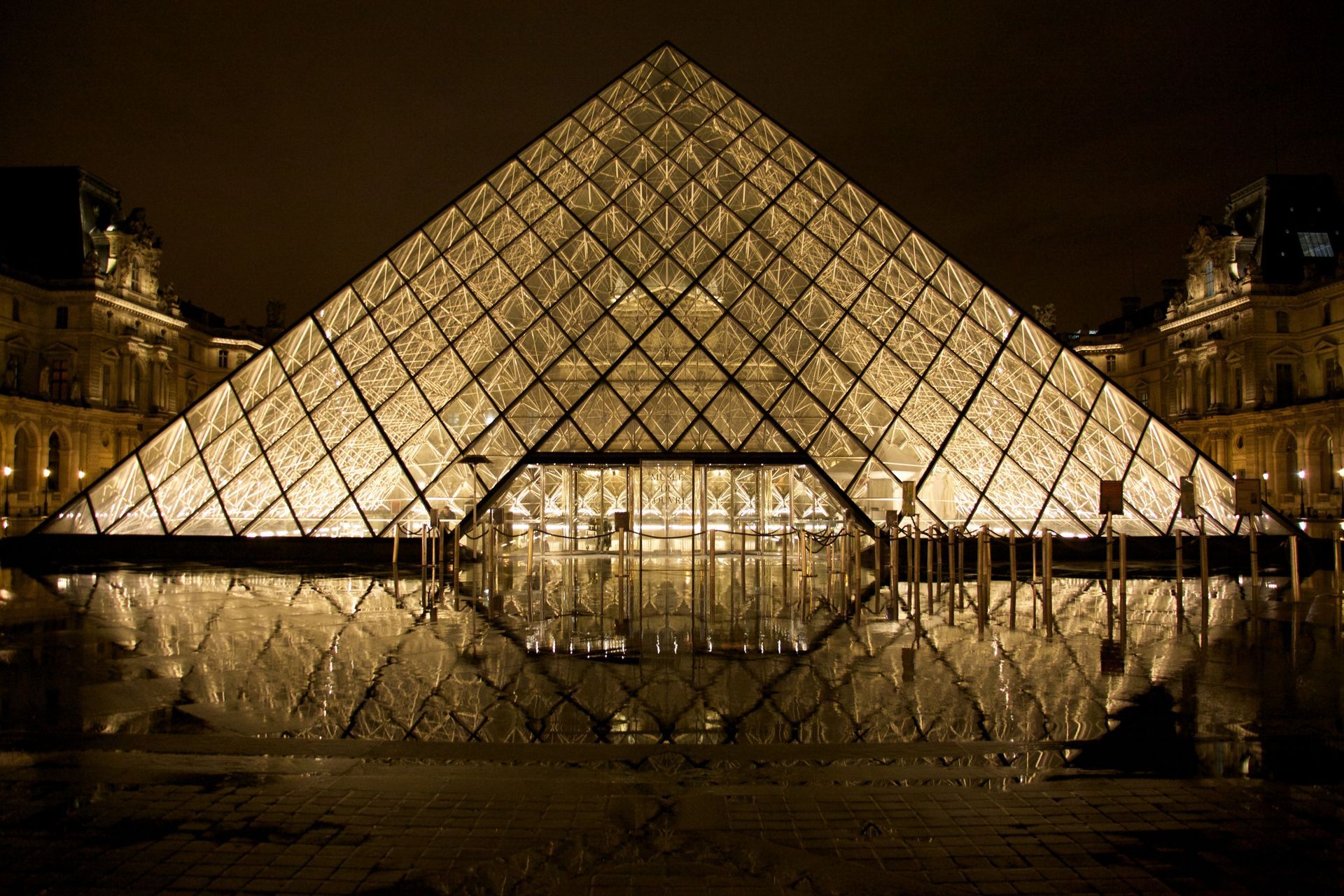 Die beleuchtete Glaspyramide des Louvre-Museums bei Nacht.