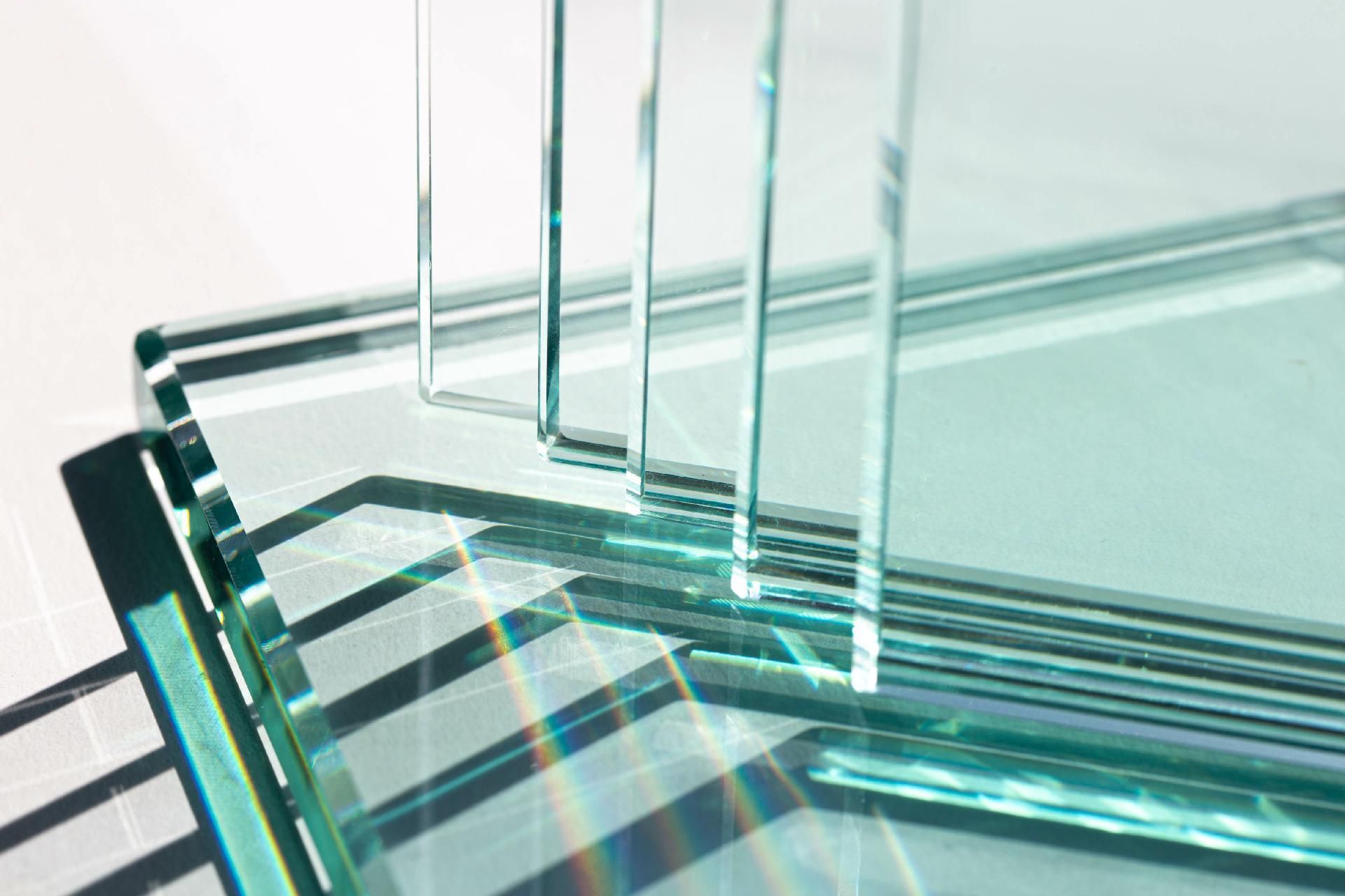 Gestapelte und aneinander gelehnte Glasplatten reflektieren das Licht.