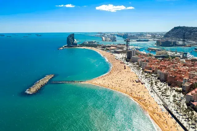 Una vista aérea de una playa con una ciudad al fondo.