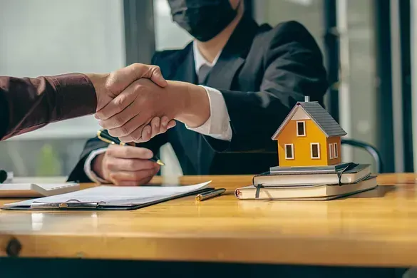 Un hombre que lleva una máscara le da la mano a otro hombre.