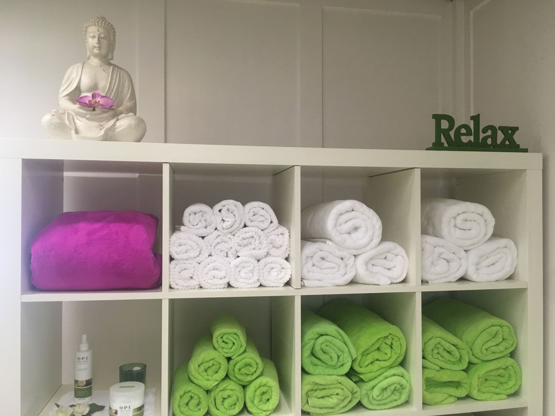 Ein Regal voller Handtücher und ein Schild mit der Aufschrift „Relax“